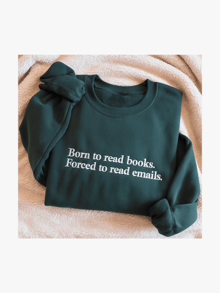 dark green sweatshirt with white text that says Born to read books. Forced to read emails. on cream blanket